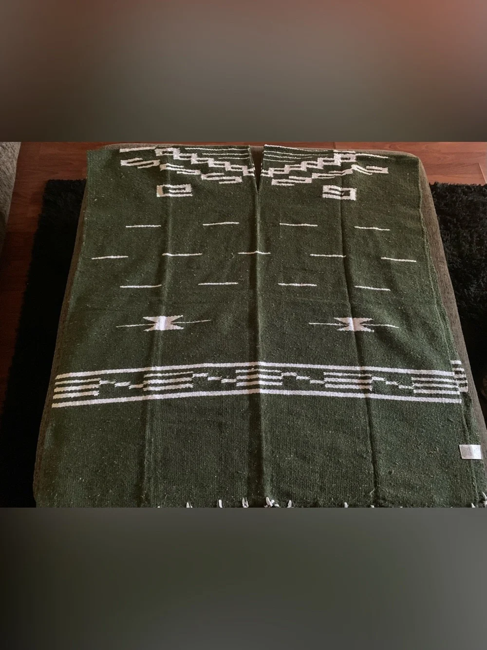 olive green Mexican-style blanket poncho featuring a geometric pattern